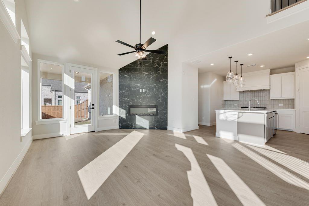 12703 Pine Ridge Trail Rowlett, TX 75089 - Photo 8 of 30 a large white kitchen with a refrigerator a stove a sink dishwasher and a dining table with wooden floor
