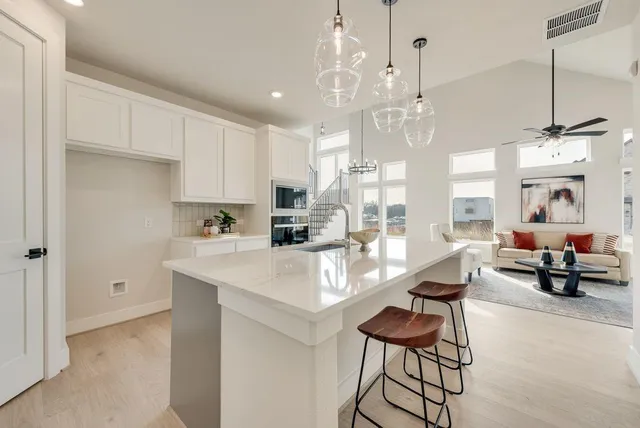 a very nice looking dining room with kitchen island stainless steel appliances furniture a chandelier and a view of kitchen