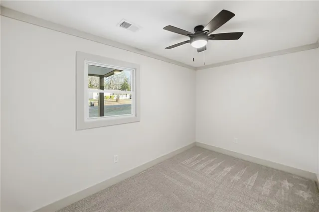 an empty room with a window and a ceiling fan
