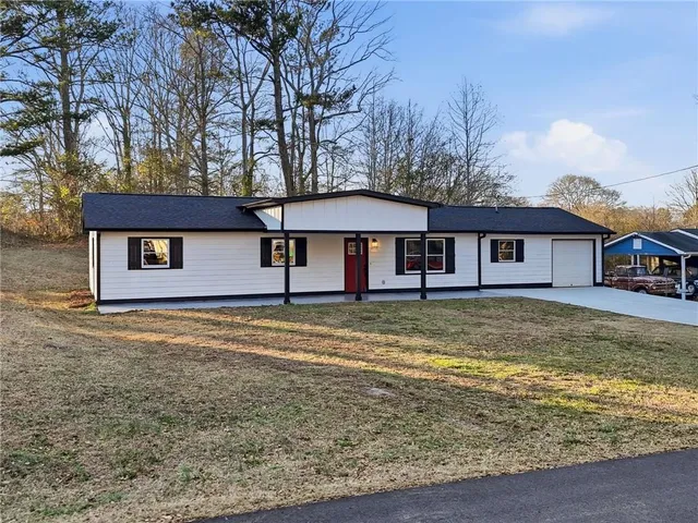 a view of a house with a yard and large tree