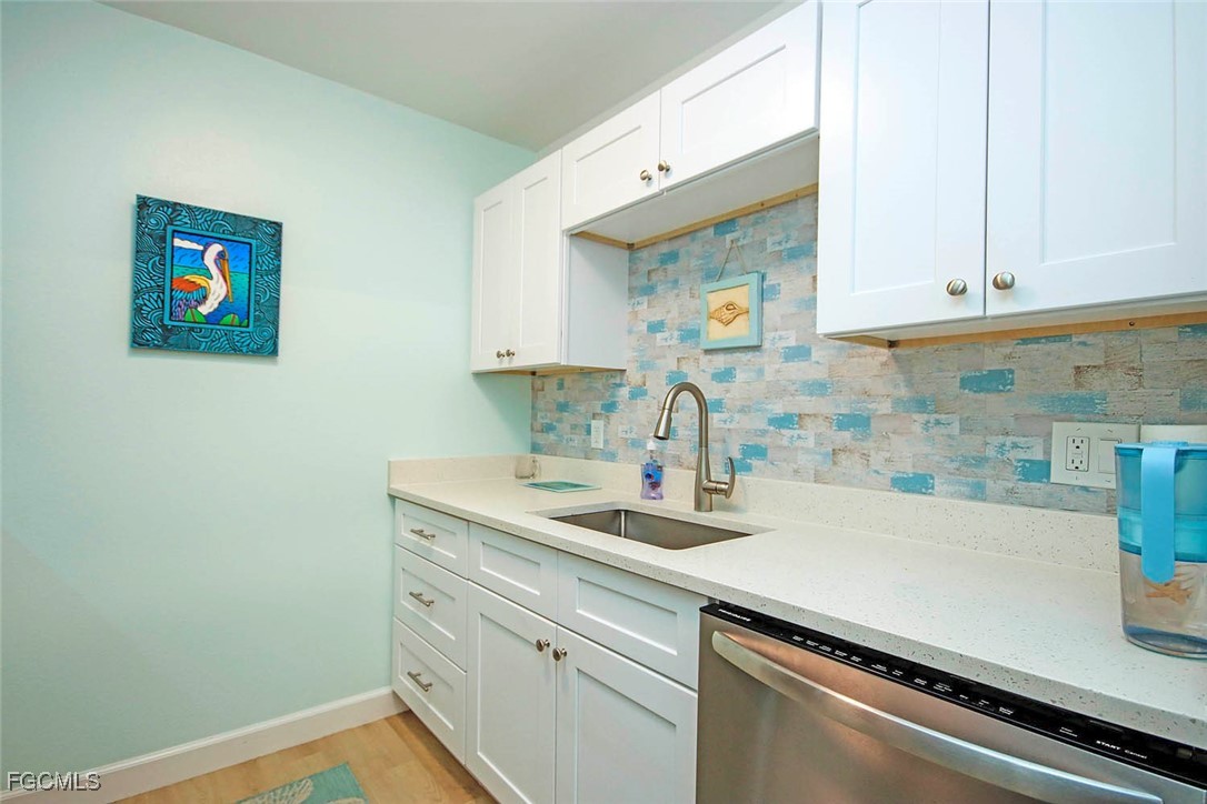 641 Periwinkle Way, Unit A3 Sanibel, FL 33957 - Photo 7 of 26 a kitchen with a sink and cabinets