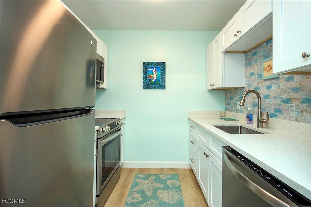 641 Periwinkle Way, Unit A3 Sanibel, FL 33957 - Photo 9 of 26 a kitchen with a sink and a refrigerator