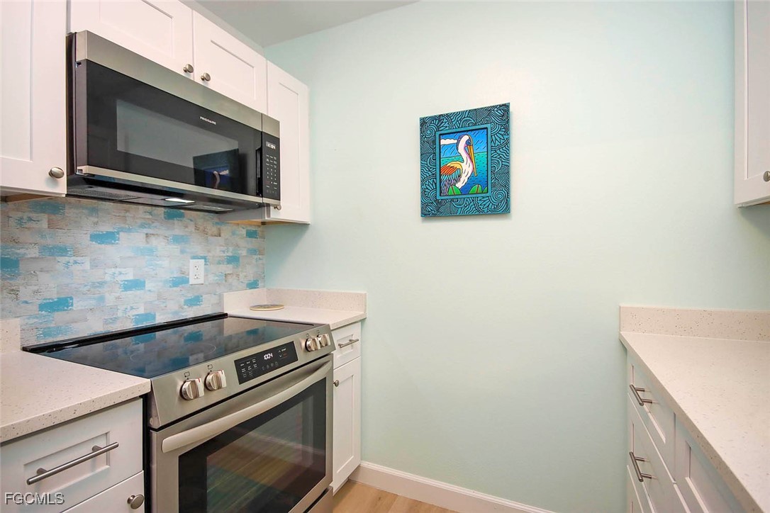 641 Periwinkle Way, Unit A3 Sanibel, FL 33957 - Photo 10 of 26 a kitchen with a stove and a microwave