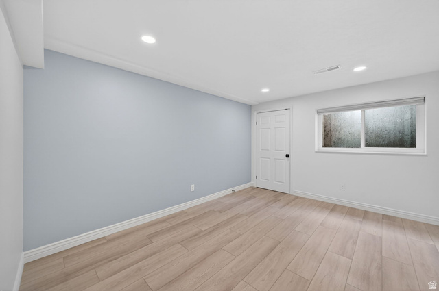 6969 South 855 East Midvale, UT 84047 - Photo 36 of 55 Spacious room featuring light wood-finish flooring, recessed lighting, a neutral gray accent wall, and white trim