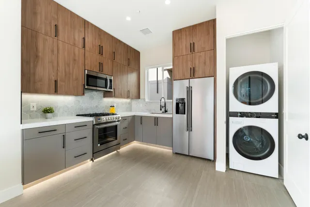 a kitchen with cabinets stainless steel appliances and a counter space