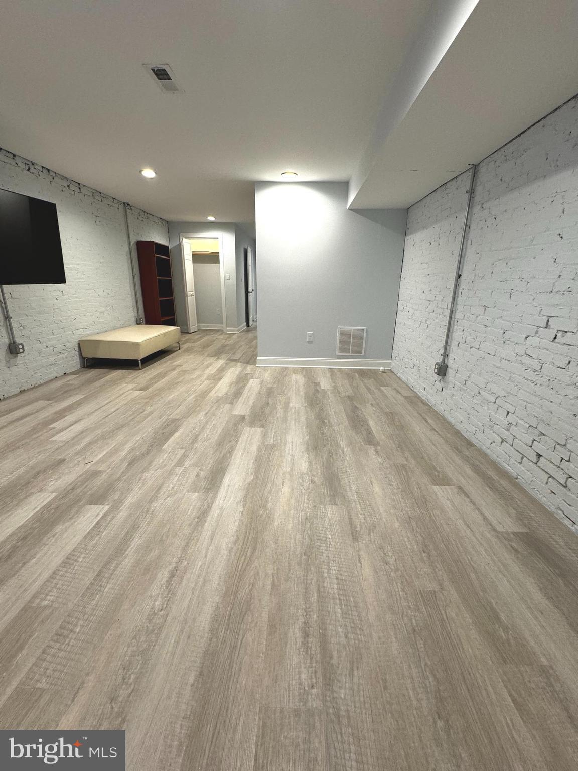 3208 Auchentoroly Terrace Baltimore, MD 21217 - Photo 23 of 25 an empty room with wooden floor and windows