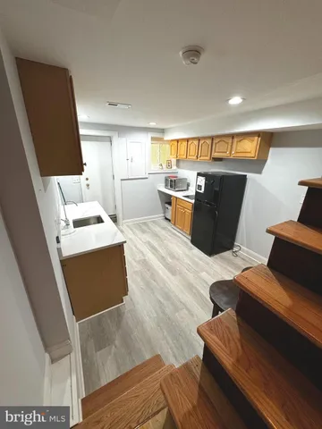a living room with couches chairs with kitchen view