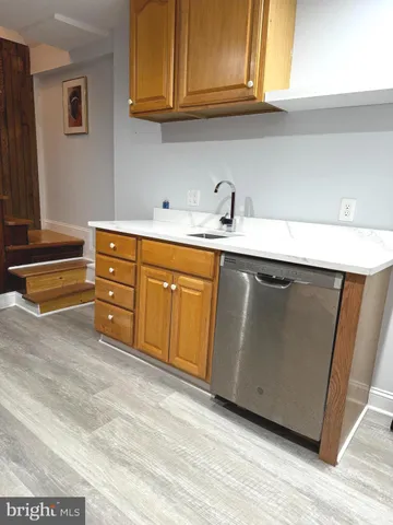 a kitchen with granite countertop a sink cabinets and stainless steel appliances