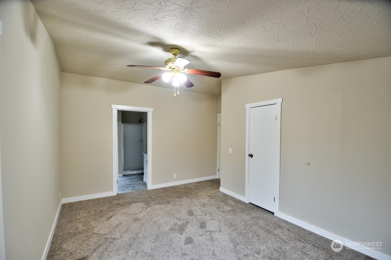 27 South Gee Creek Loop Ridgefield, WA 98642 - Photo 18 of 26 an empty room with a chandelier fan and a bathroom
