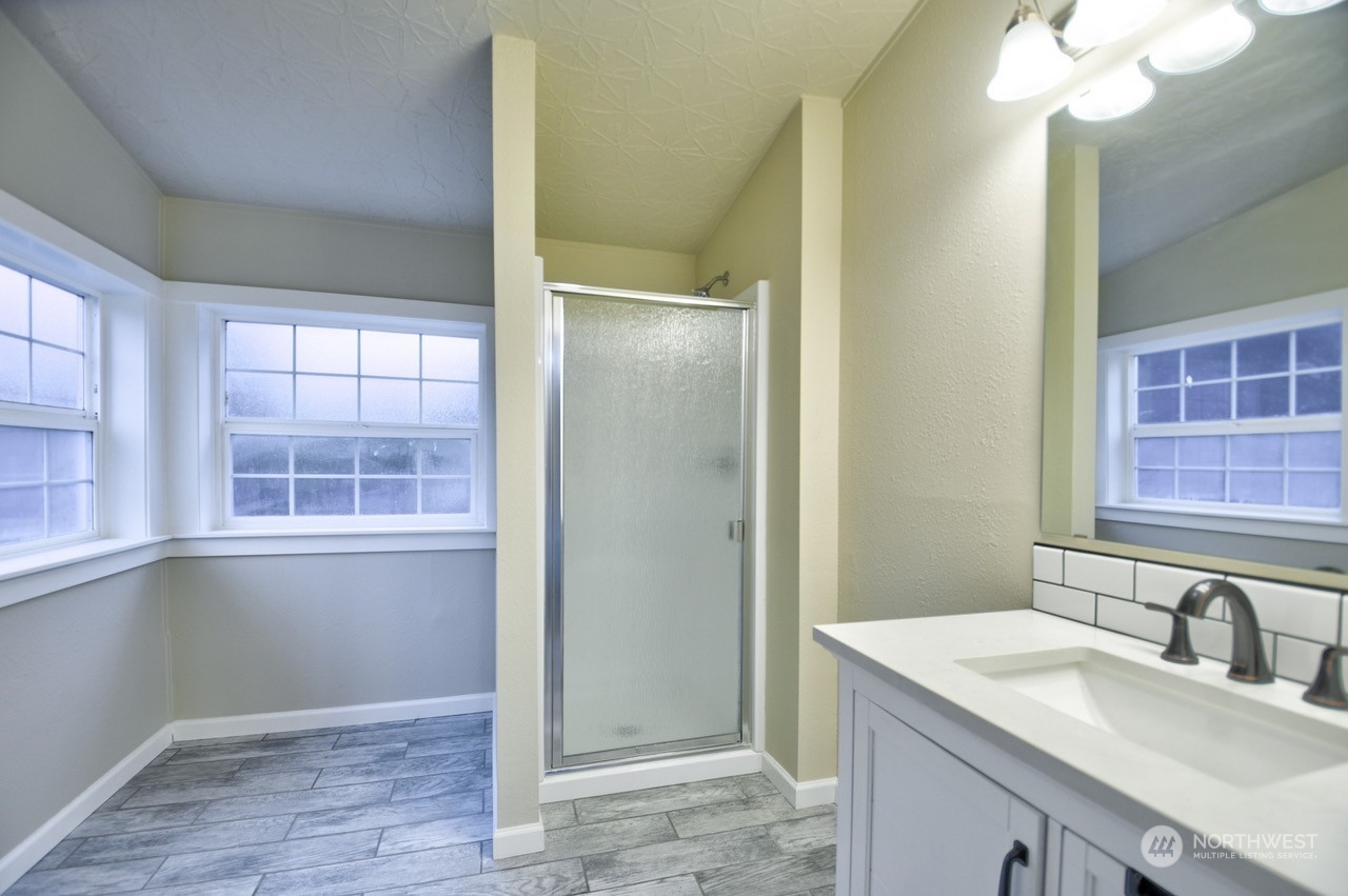 27 South Gee Creek Loop Ridgefield, WA 98642 - Photo 20 of 26 a bathroom with a granite countertop sink mirror and a shower
