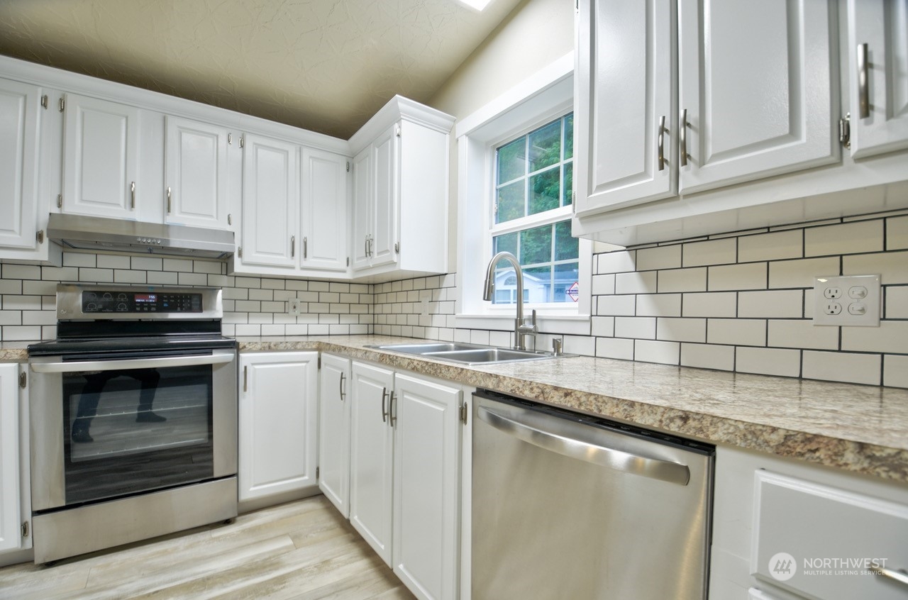 27 South Gee Creek Loop Ridgefield, WA 98642 - Photo 9 of 26 a kitchen with stainless steel appliances granite countertop a sink stove and cabinets