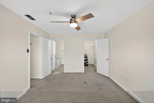a view of an empty room with a ceiling fan