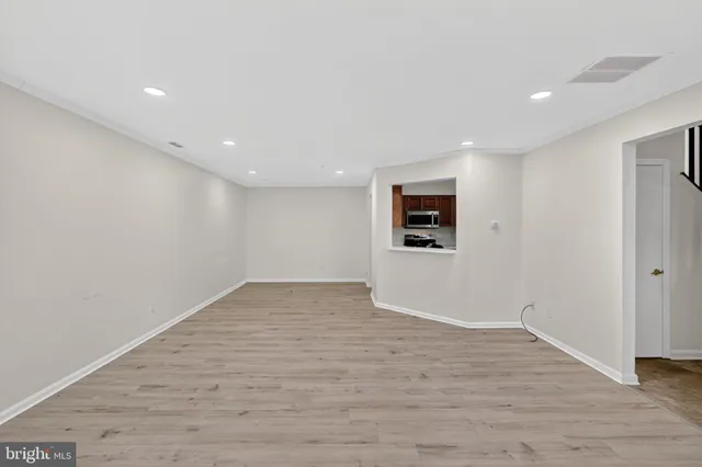 a view of a big room with wooden floor and windows