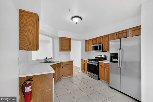 a kitchen with stainless steel appliances granite countertop a refrigerator sink and stove