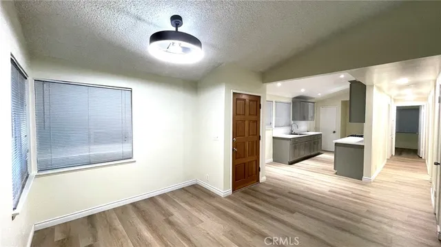 a view of a big room with wooden floor and windows