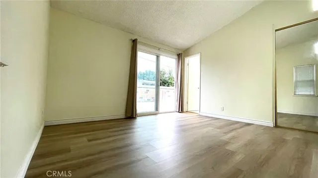 a hallway with white cabinets and wooden floor