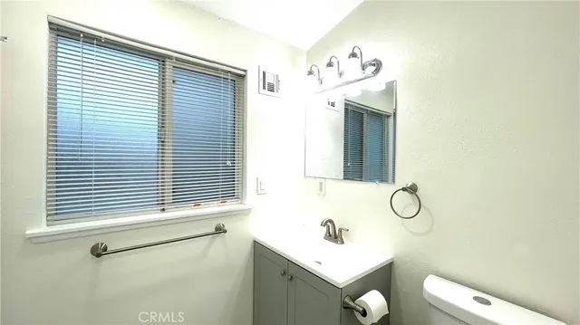 a bathroom with a sink and mirror with toilet