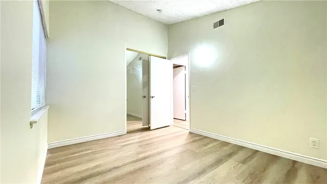 a view of a room with wooden floor and a window