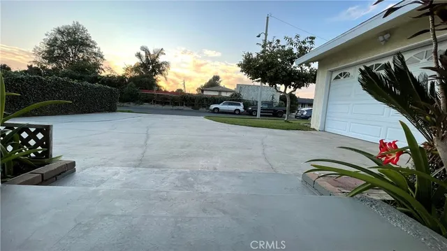 a vase of flowers sitting on a floor in front of a house