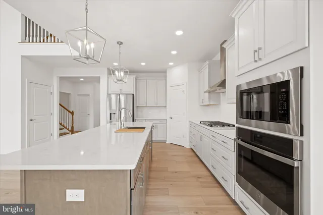 a kitchen with kitchen island a sink stainless steel appliances and cabinets