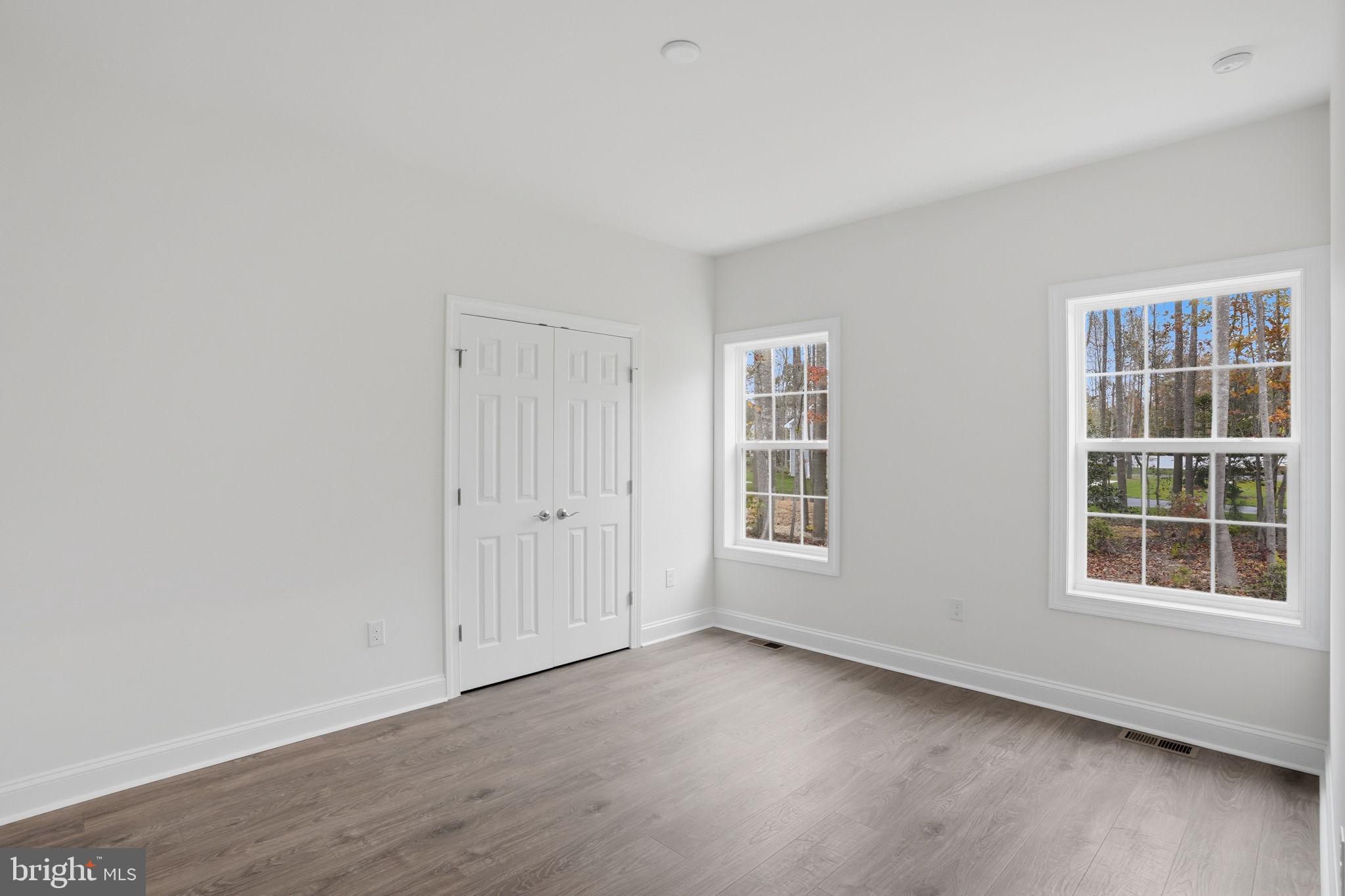 24025 Jerrico Road, Unit 38 Lincoln, DE 19960 - Photo 12 of 32 an empty room with wooden floor and windows