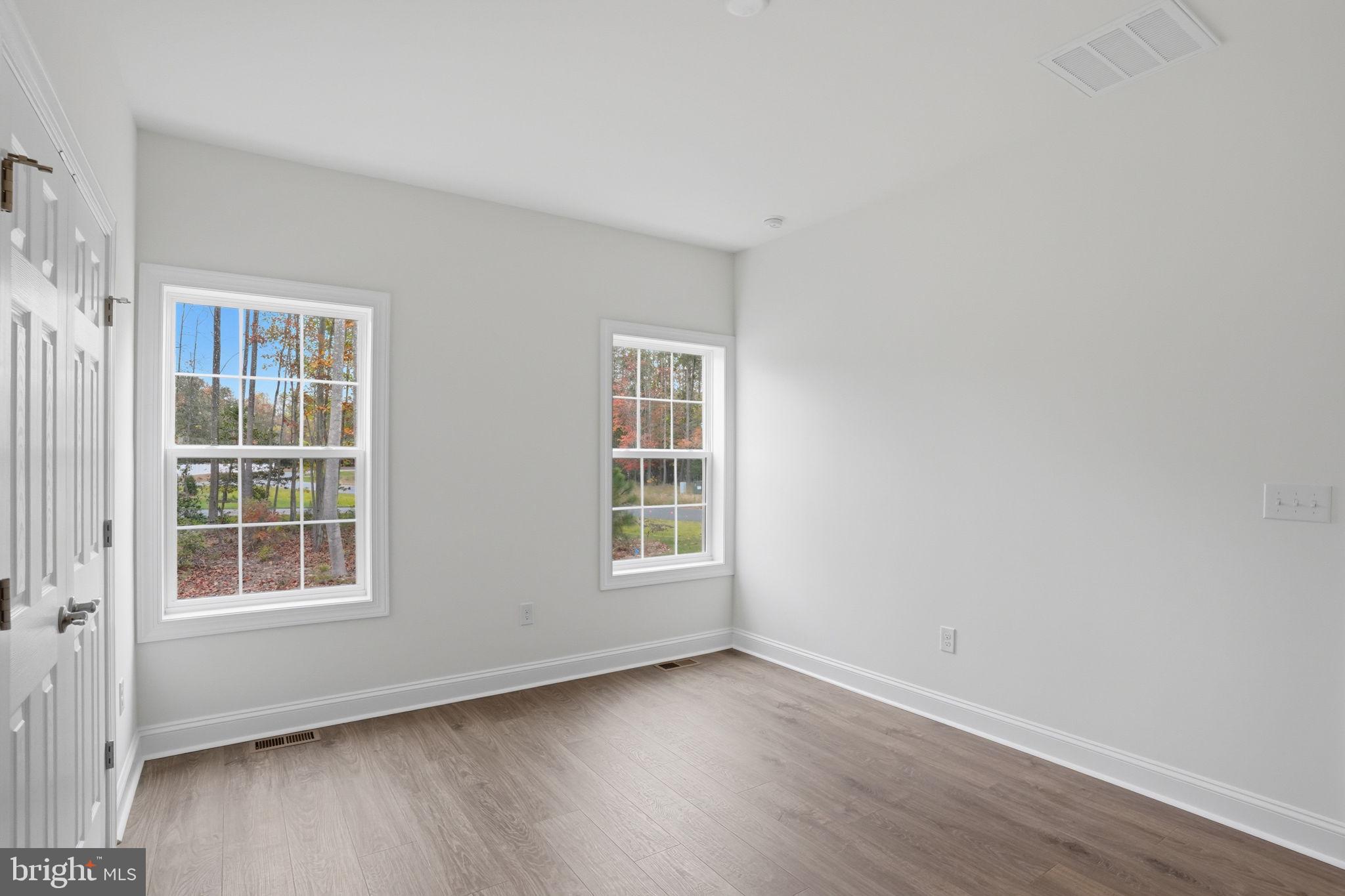 24025 Jerrico Road, Unit 38 Lincoln, DE 19960 - Photo 13 of 32 an empty room with wooden floor and windows