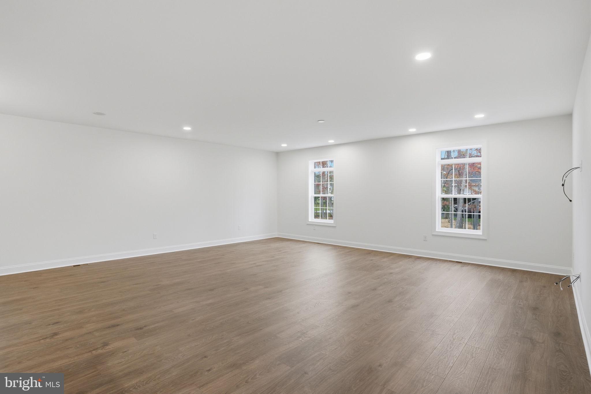24025 Jerrico Road, Unit 38 Lincoln, DE 19960 - Photo 22 of 32 a view of an empty room with wooden floor and windows