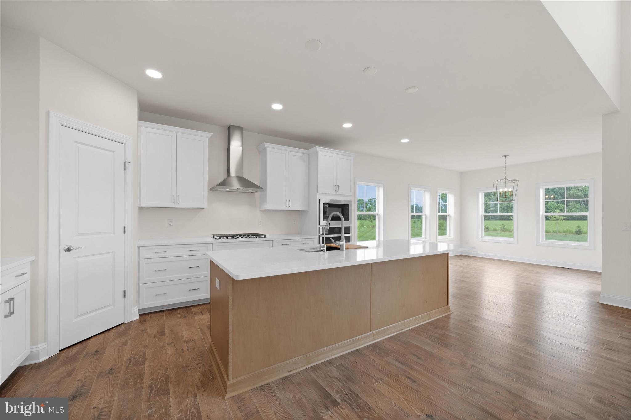 24025 Jerrico Road, Unit 38 Lincoln, DE 19960 - Photo 24 of 53 a large kitchen with cabinets wooden floor and stainless steel appliances