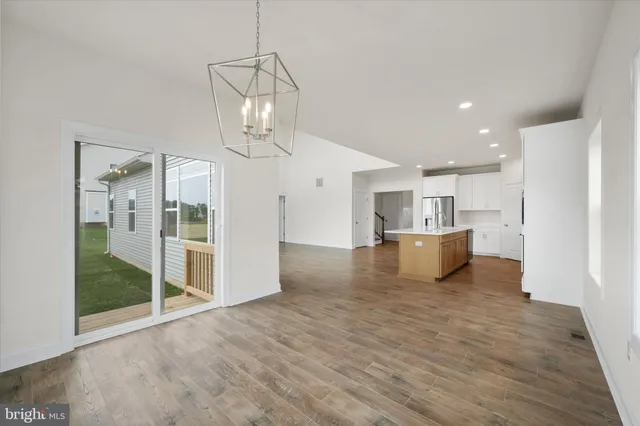 a large kitchen with stainless steel appliances granite countertop a large counter top and a wooden floors