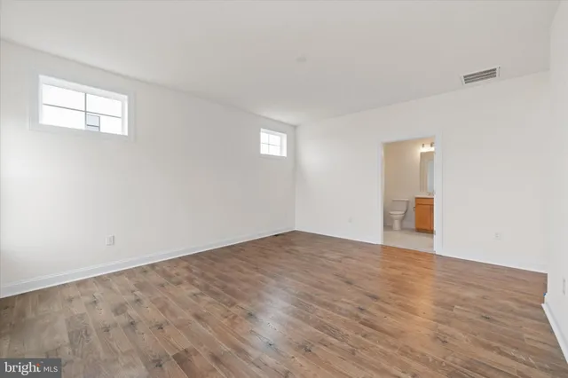 a spacious bathroom with a toilet sink and mirror