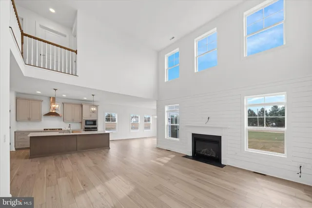 a living room with stainless steel appliances kitchen island a table and a fireplace