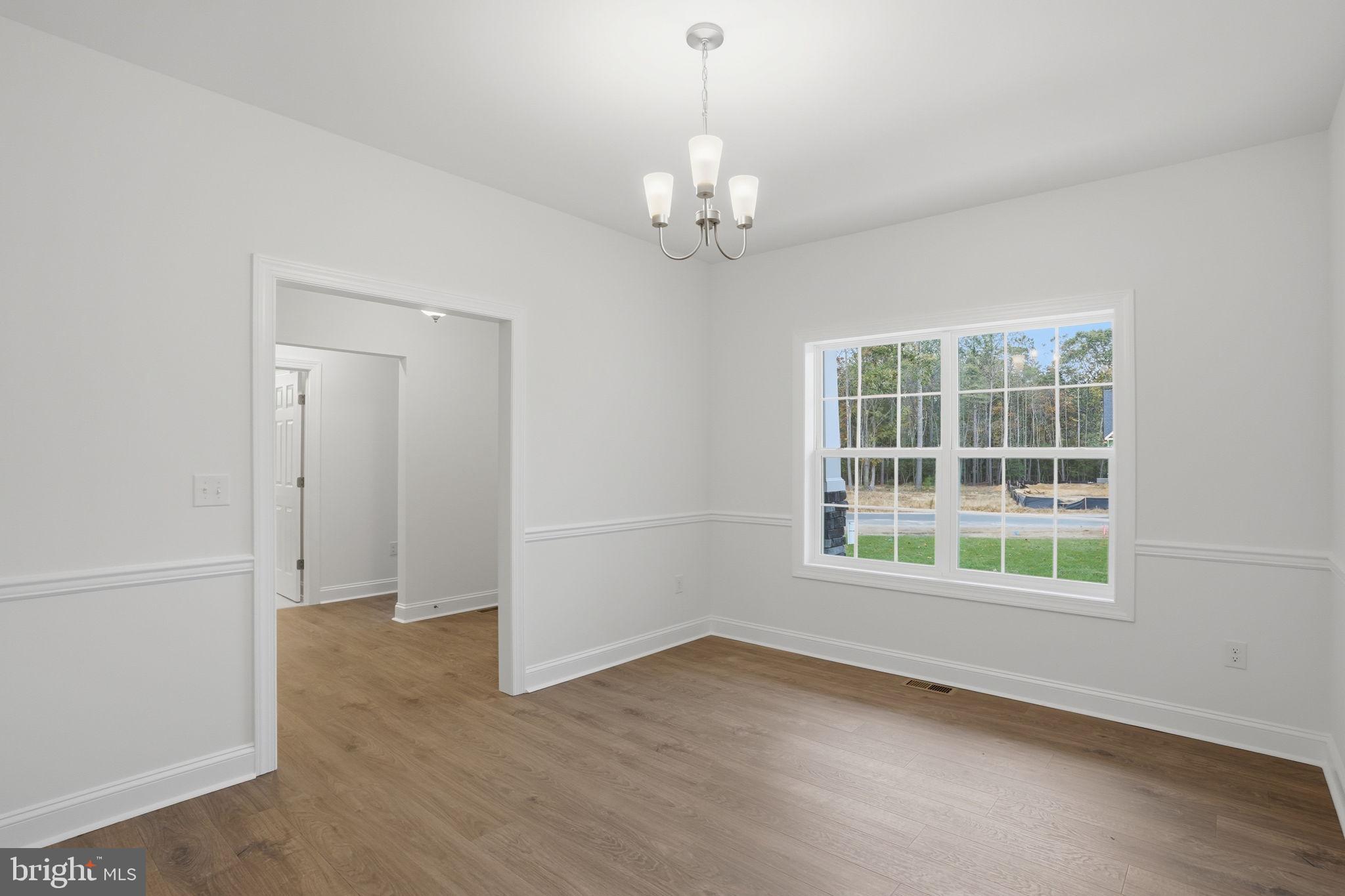 24025 Jerrico Road, Unit 38 Lincoln, DE 19960 - Photo 7 of 32 an empty room with a windows and chandelier