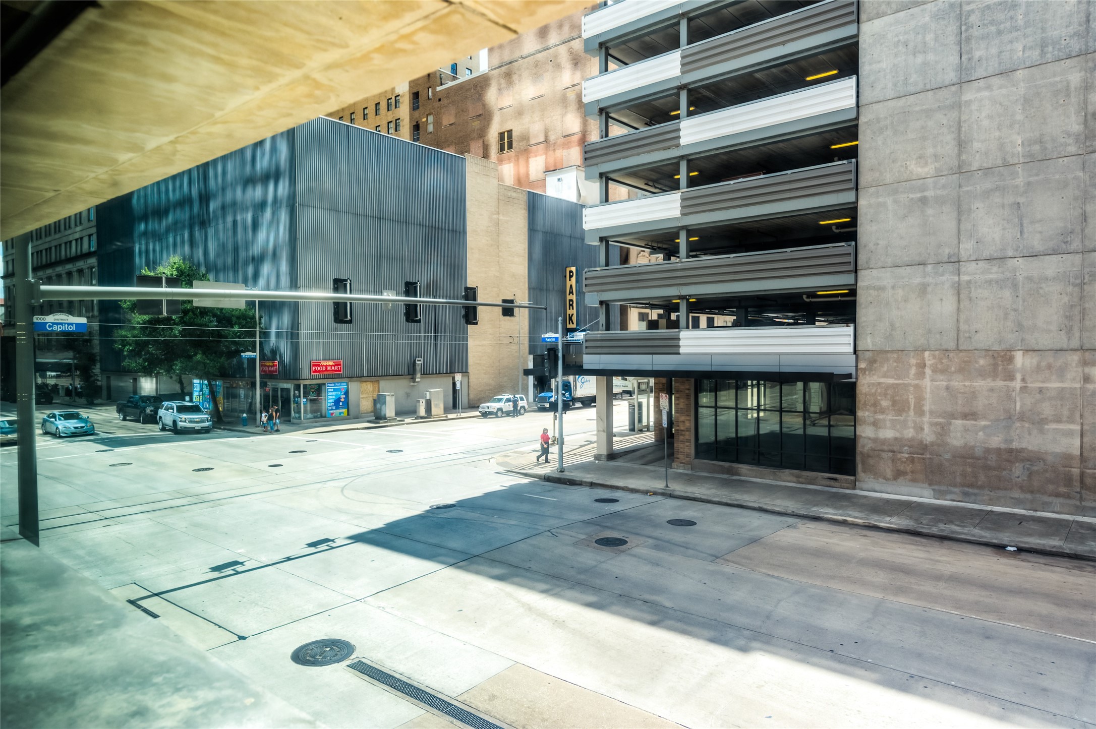 705 Main Street, Unit 215 Houston, TX 77002 - Photo 27 of 36 Urban view featuring a street corner with a parking garage and modern commercial buildings. Wide sidewalks and minimal traffic provide a spacious city feel.
