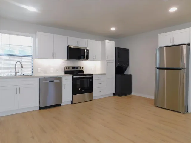 a kitchen with a refrigerator and a stove top oven
