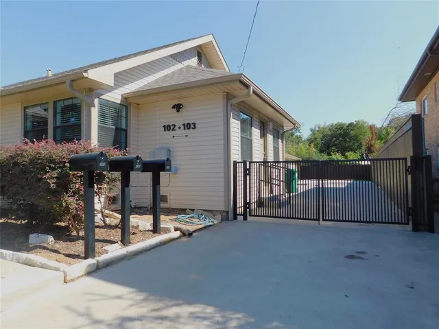 a view of house with small yard and wooden fence