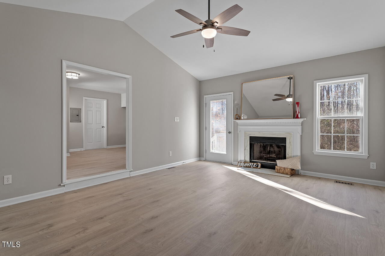5404 Passenger Place Raleigh, NC 27603 - Photo 11 of 25 a view of a livingroom with a fireplace a ceiling fan and windows