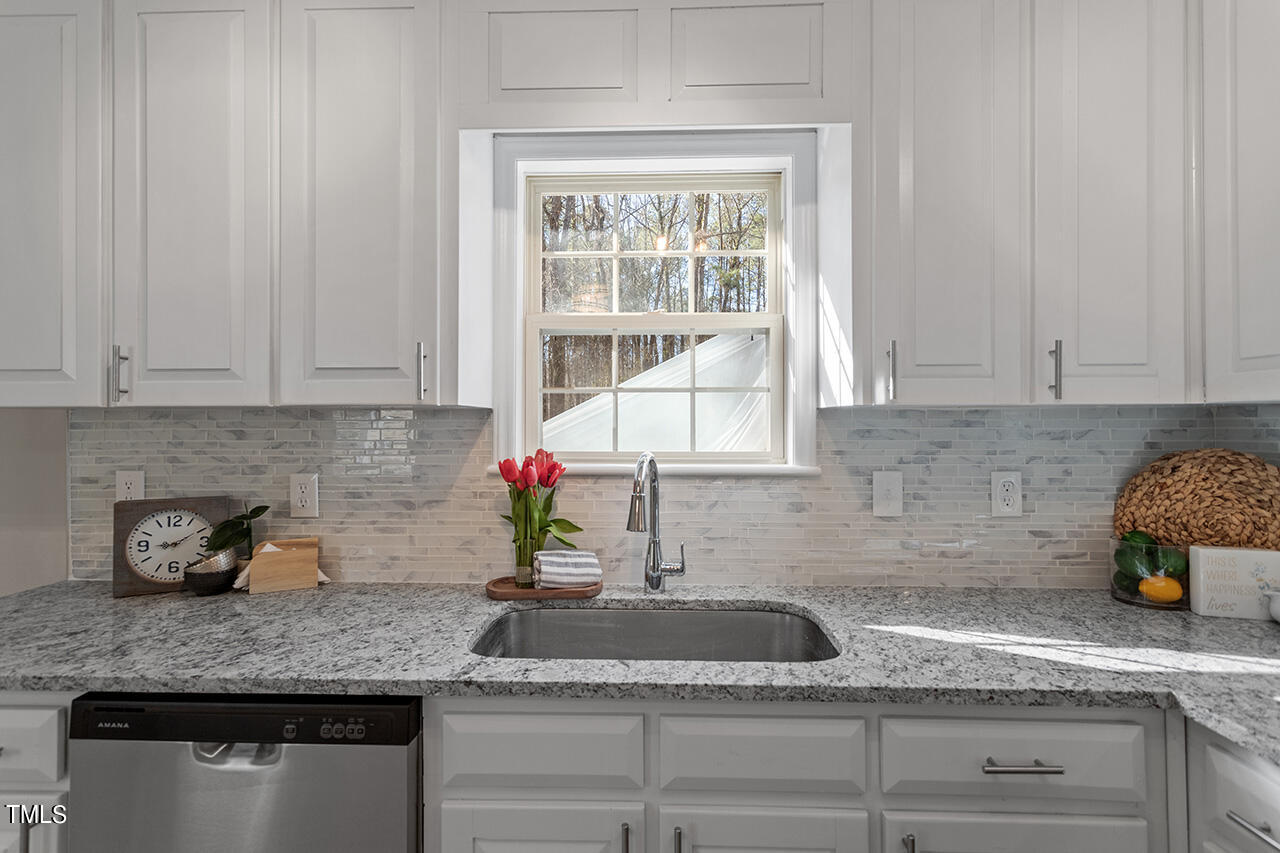 5404 Passenger Place Raleigh, NC 27603 - Photo 4 of 25 a kitchen with granite countertop a sink a window and potted plant