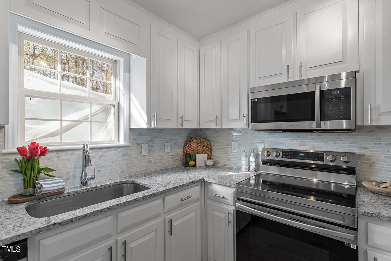 5404 Passenger Place Raleigh, NC 27603 - Photo 5 of 25 a kitchen with granite countertop white cabinets stainless steel appliances and a sink