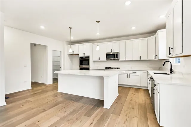 a kitchen with stainless steel appliances a refrigerator sink and cabinets