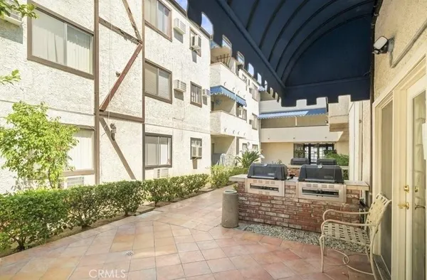 a building outdoor space with patio furniture and potted plants