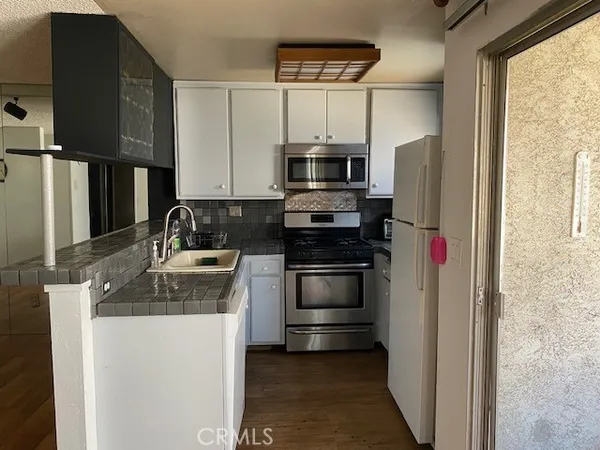 a kitchen with stainless steel appliances granite countertop a refrigerator sink and stove
