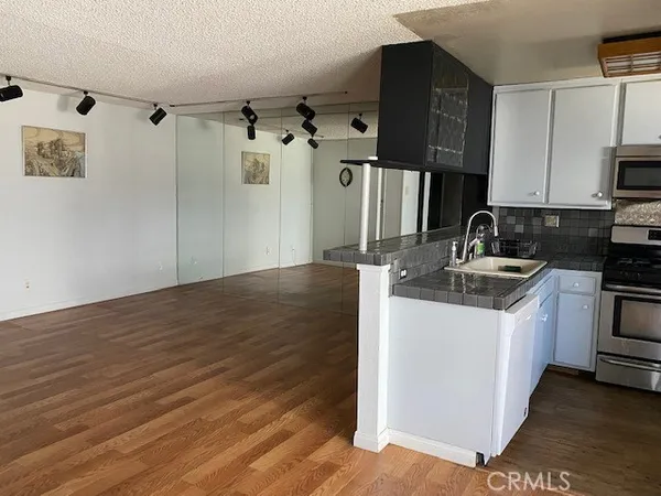 a kitchen with granite countertop a sink and cabinets
