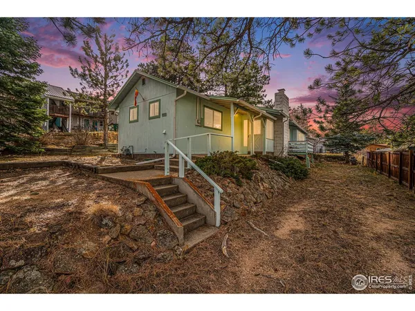 a backyard of a house with wooden fence and large trees