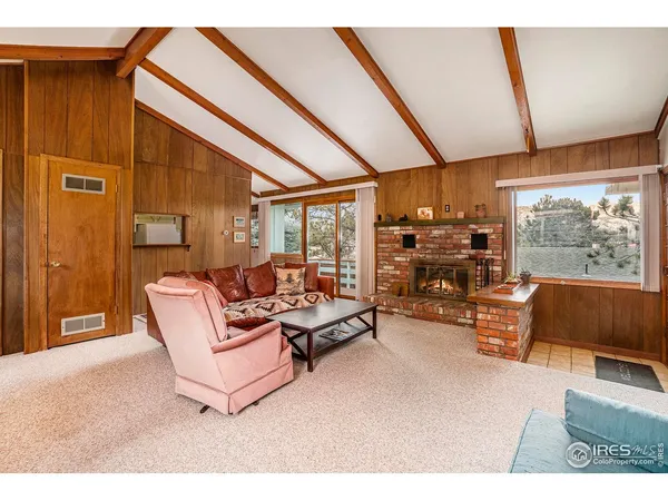 a living room with furniture a flat screen tv and floor to ceiling window