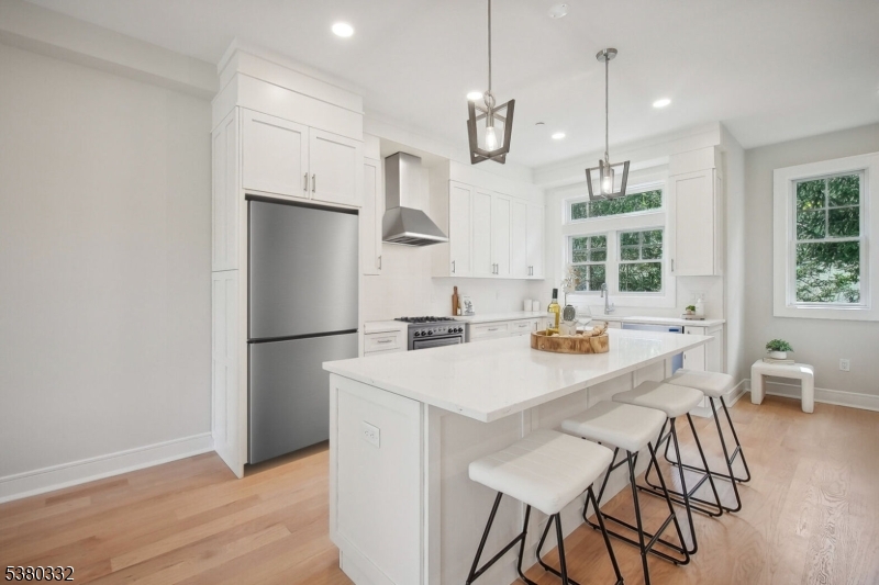 603 Springfield Avenue, Unit 102 Summit, NJ 07901 - Photo 3 of 5 a kitchen with stainless steel appliances a refrigerator a sink a dining table and chairs