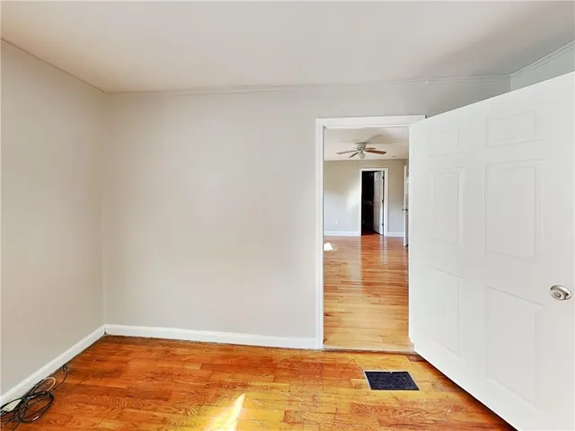 a view of a hallway with wooden floor and a window