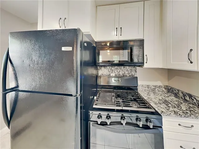a kitchen with stainless steel appliances granite countertop a stove and a refrigerator