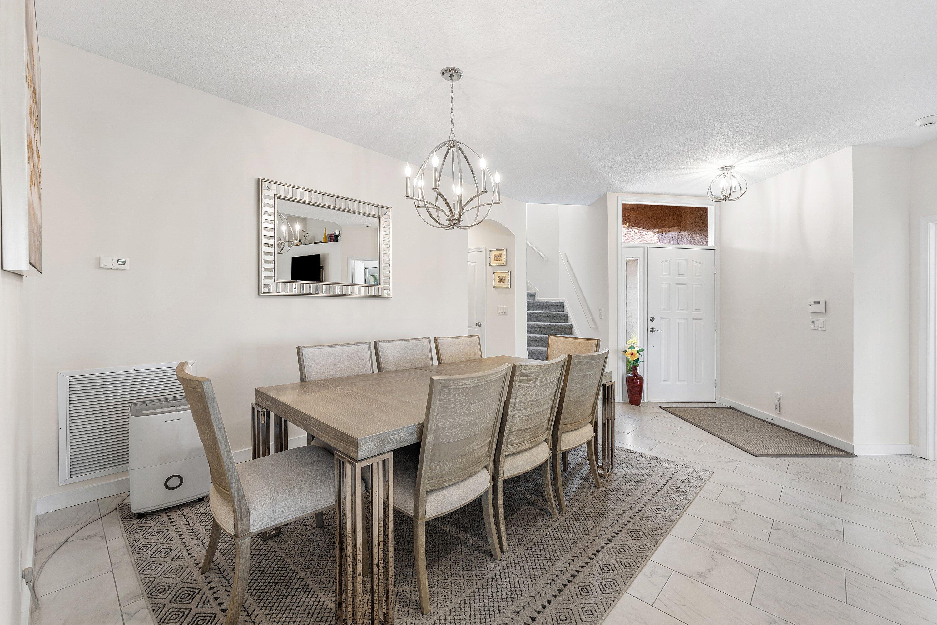 8217 Quail Meadow Way West Palm Beach, FL 33412 - Photo 12 of 38 a view of a dining room with furniture and a chandelier