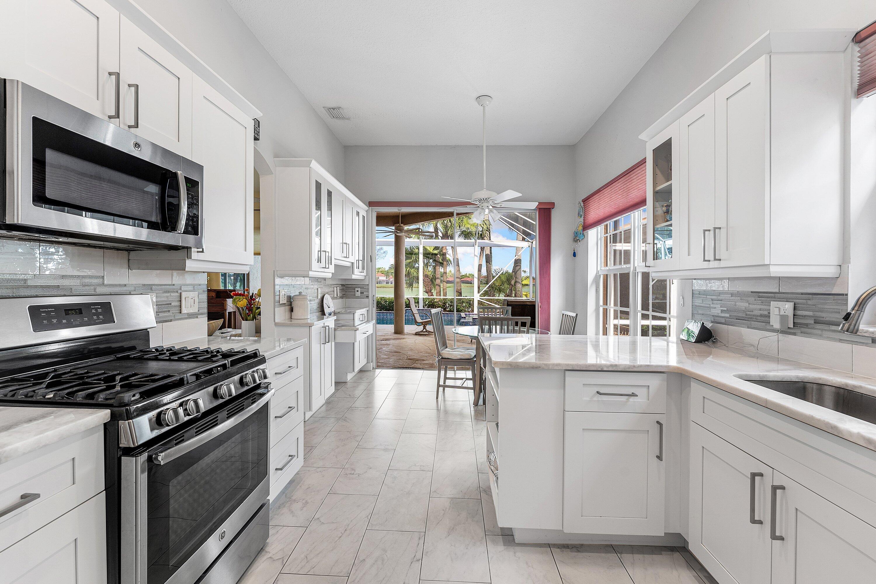 8217 Quail Meadow Way West Palm Beach, FL 33412 - Photo 13 of 38 a kitchen with stainless steel appliances a stove sink microwave and cabinets