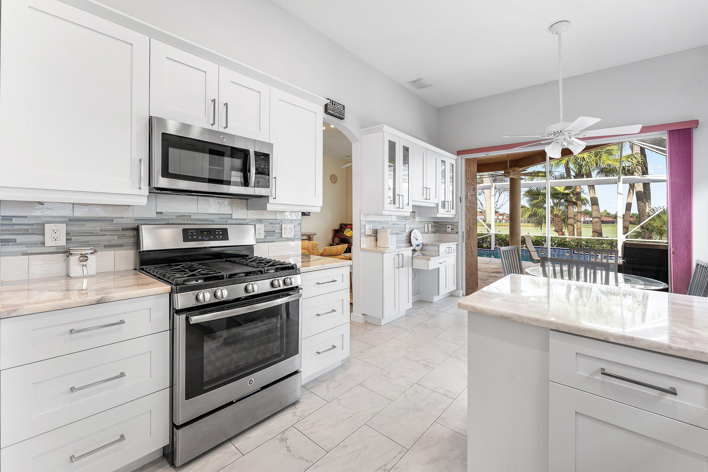 8217 Quail Meadow Way West Palm Beach, FL 33412 - Photo 14 of 38 a kitchen with stainless steel appliances granite countertop a stove a sink and a microwave
